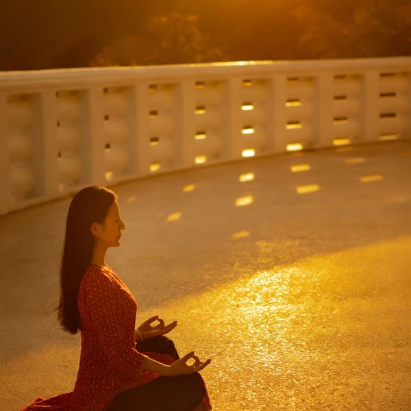 Silhouette of a person meditating during sunset.